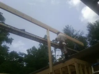 Carpenter setting a ridge beam over a new addition frame — Ice Dam Removal by Roofing Brothers in Okarche