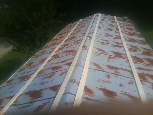 Rusted metal roof panels with new wood purlins before replacement — Storm Damage Roof Repair in Okarche by Roofing Brothers