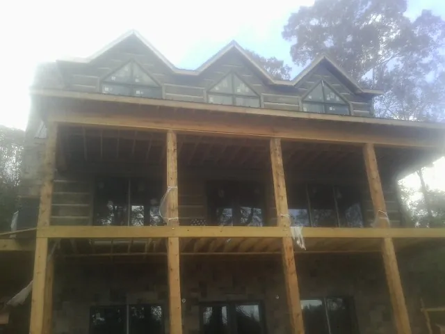 Dormers and porch framing on a large log home under construction — Roof Coating work by our crew in Okarche