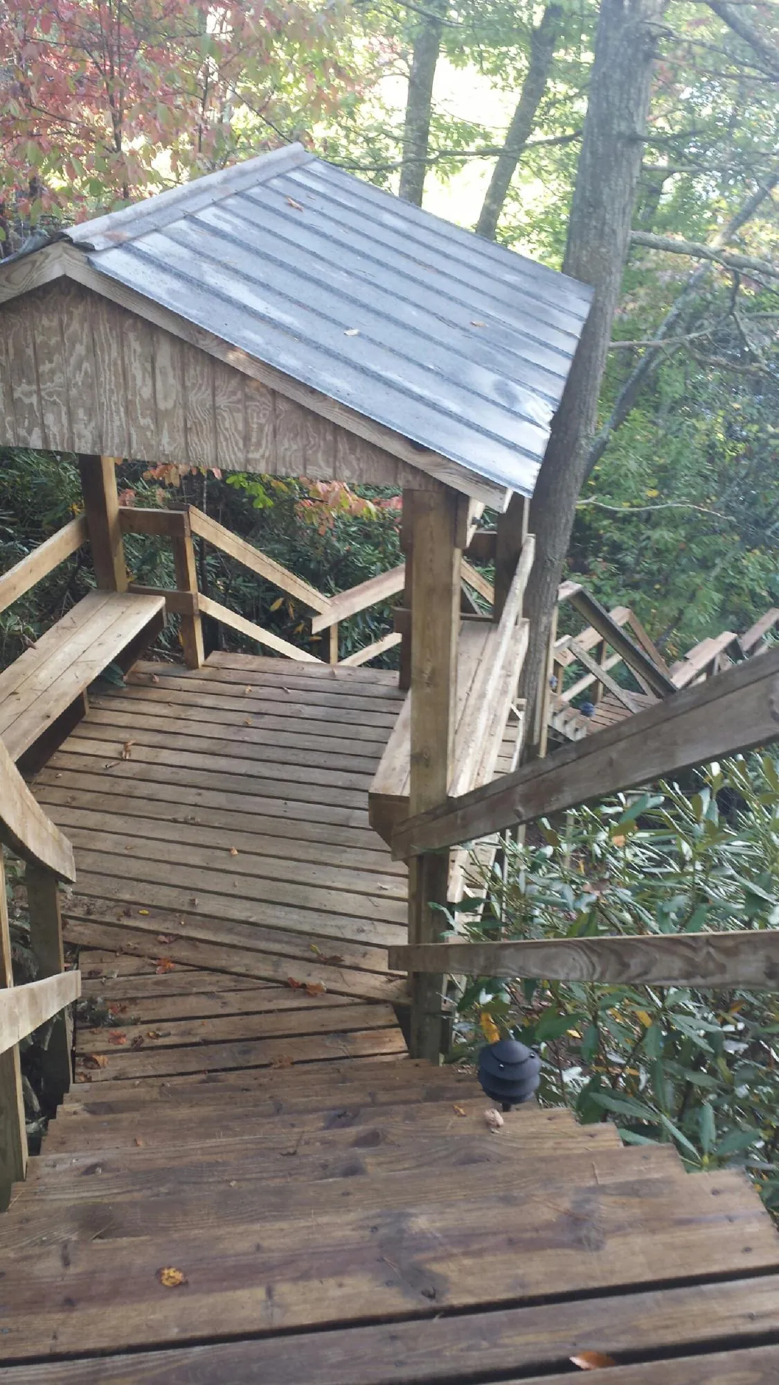 Metal roofed shelter over wooden steps on a wooded walkway — Skylight Repair & Installation work by our crew in Okarche