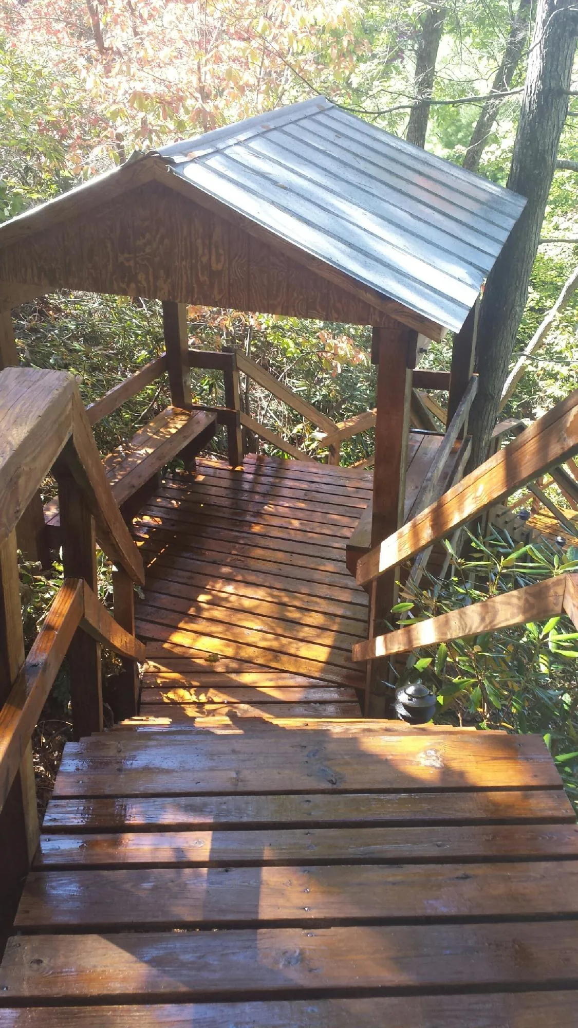 Freshly stained wood walkway and covered shelter with a metal roof in Okarche