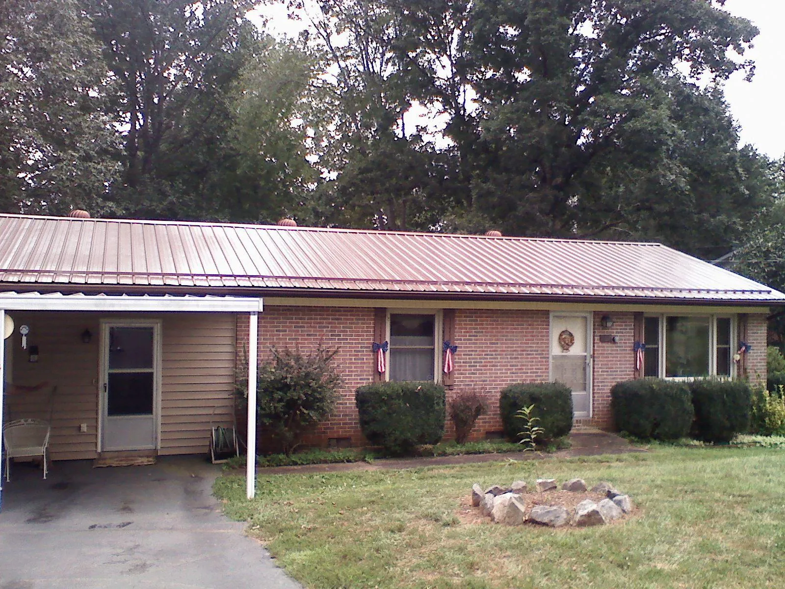 Bronze metal roof and carport on a brick ranch home — Roof Repair work by our crew in Okarche